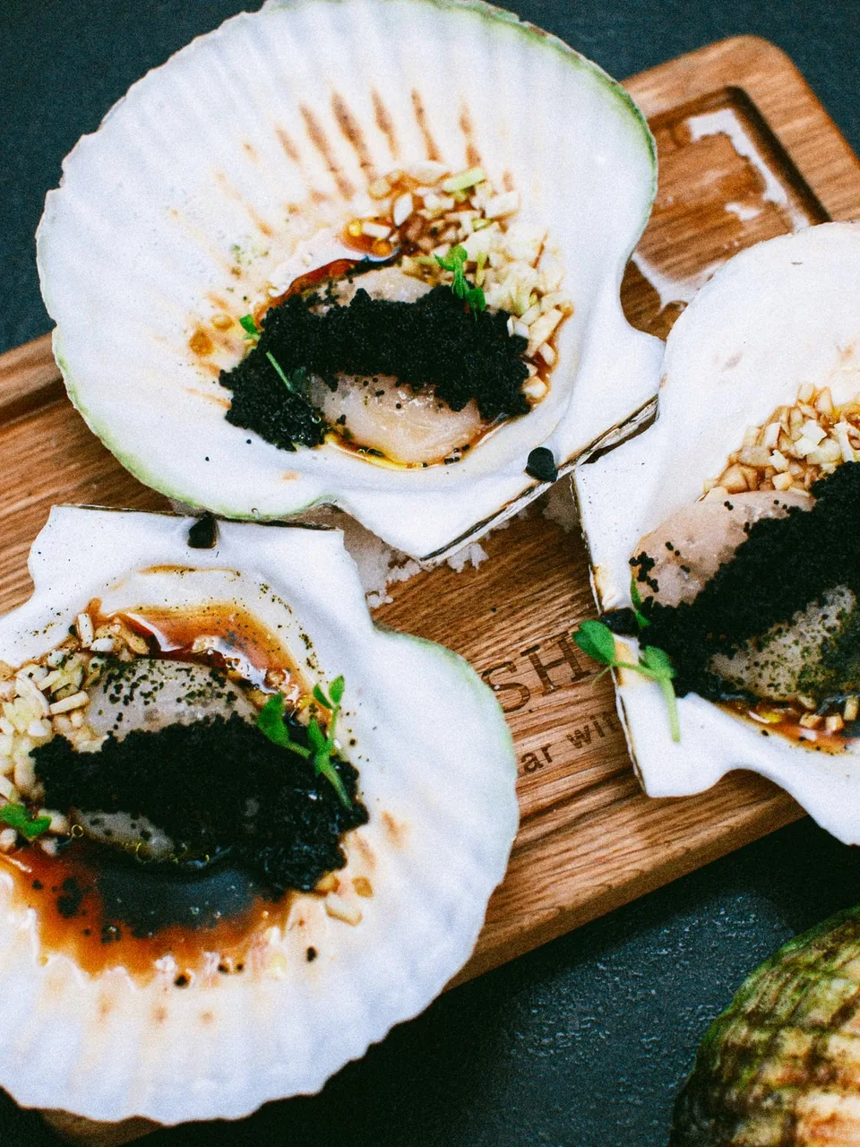 Scallops in their shells with caviar and sea herbs