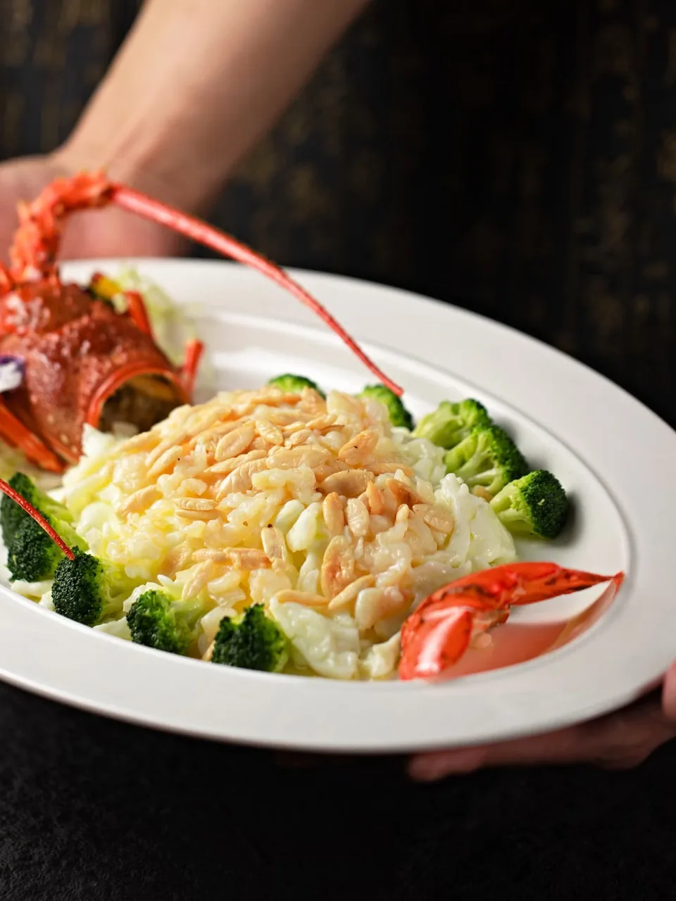 Lobster served on a white plate with greens